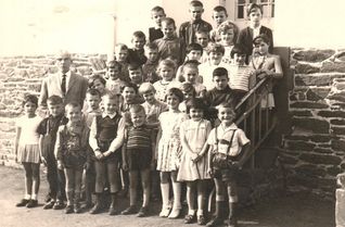 Historische Aufnahme der Volksschule Wallscheid. Das Foto zeigt die Schuljahrgänge 1956 bis 1964 mit Lehrer Hans Oelker.