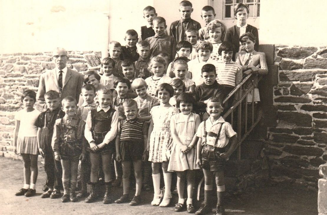 Historische Aufnahme der Volksschule Wallscheid. Das Foto zeigt die Schuljahrgänge 1956 bis 1964 mit Lehrer Hans Oelker.