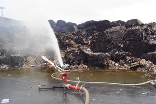 Zwei Wasserwerfer sind auch nach dem Ende des Feuerwehreinsatzes noch auf dem Gelände im Einsatz.