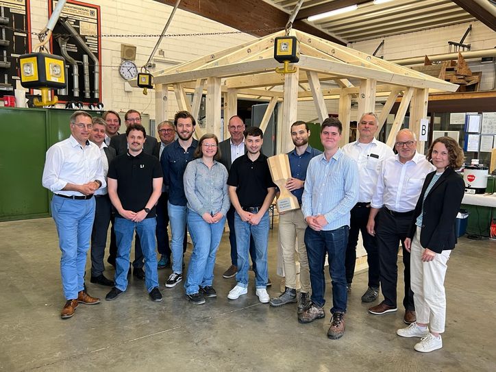 Die Gewinner des Wettbewerbs (Jana Geller, Florian Klein-Reesink, Tristan Nelissen, Hendrik Omsels und Amon Verlinde) erhalten den Wanderpokal »Holzbau Champions FH AACHEN«.