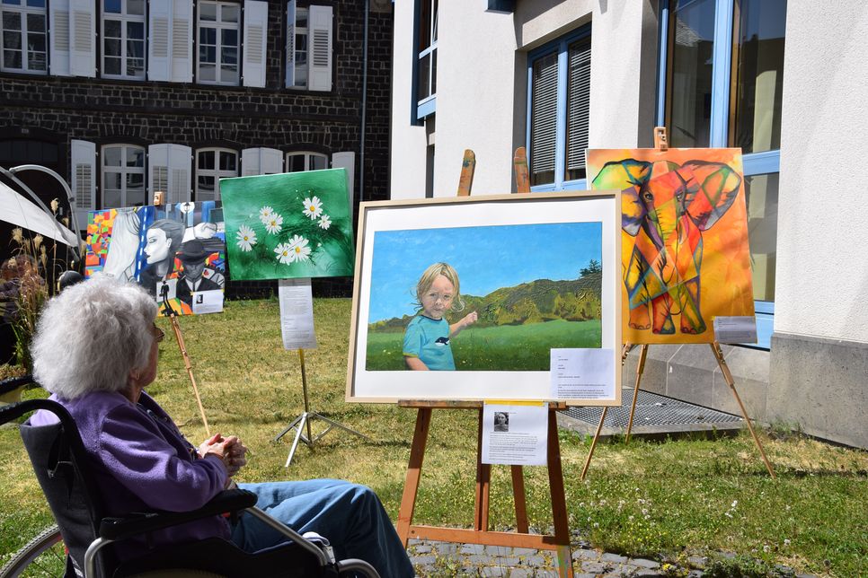 Bewohnerin betrachtet Kunstwerke im Pfarrgarten. Foto: Altenzentrum St. Johannes, Mayen