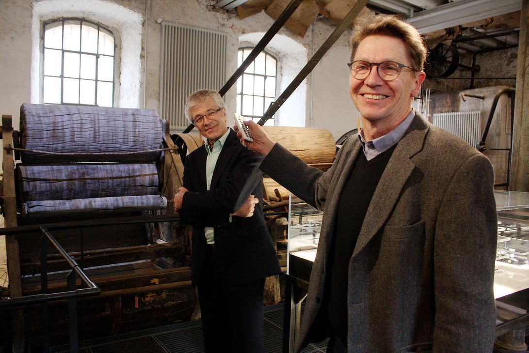 Per Knopfdruck können Detlef Stender (r.), Leiter der Tuchfabrik Müller, und Dr. Walter Hauser, Direktor des LVR-Industriemuseums, eine alte Waschmaschine mit einer Projektion von plätscherndem Wasser scheinbar wieder in Gang setzen. Foto: ProfiPress