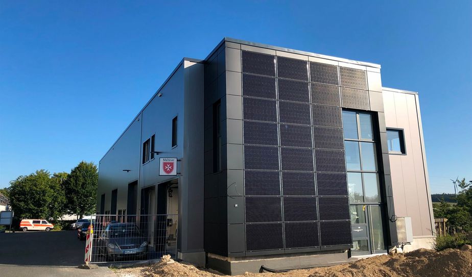 Erbaut von der Firma Nußbaum bekommen die Malteser Monschauer Land am Trafoweg in Lammersdorf eine neue Heimat. Nicht nur Halle und Räume sind modern und maßgeschneidert eingerichtet, auch die Außenfassdae wurden mit vertikalen Photovoltaik-Modulen verkleidet.