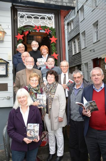 Die Macher des Geschichtsvereins Monschauer Land und Alexander Lenders (r.), Geschäftsführer des Weiss-Verlag, präsentieren in der weihnachtlichen Monschauer Altstadt das Jahrbuch 2020 - die älteste Publikation im Medienhaus Weiss. Foto: T. Förster