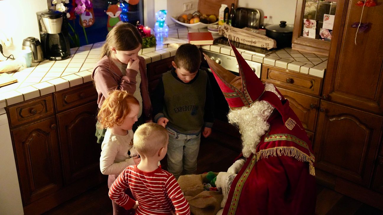 Der "Heilige Nikolaus" übergibt Geschenke an die Kinder.