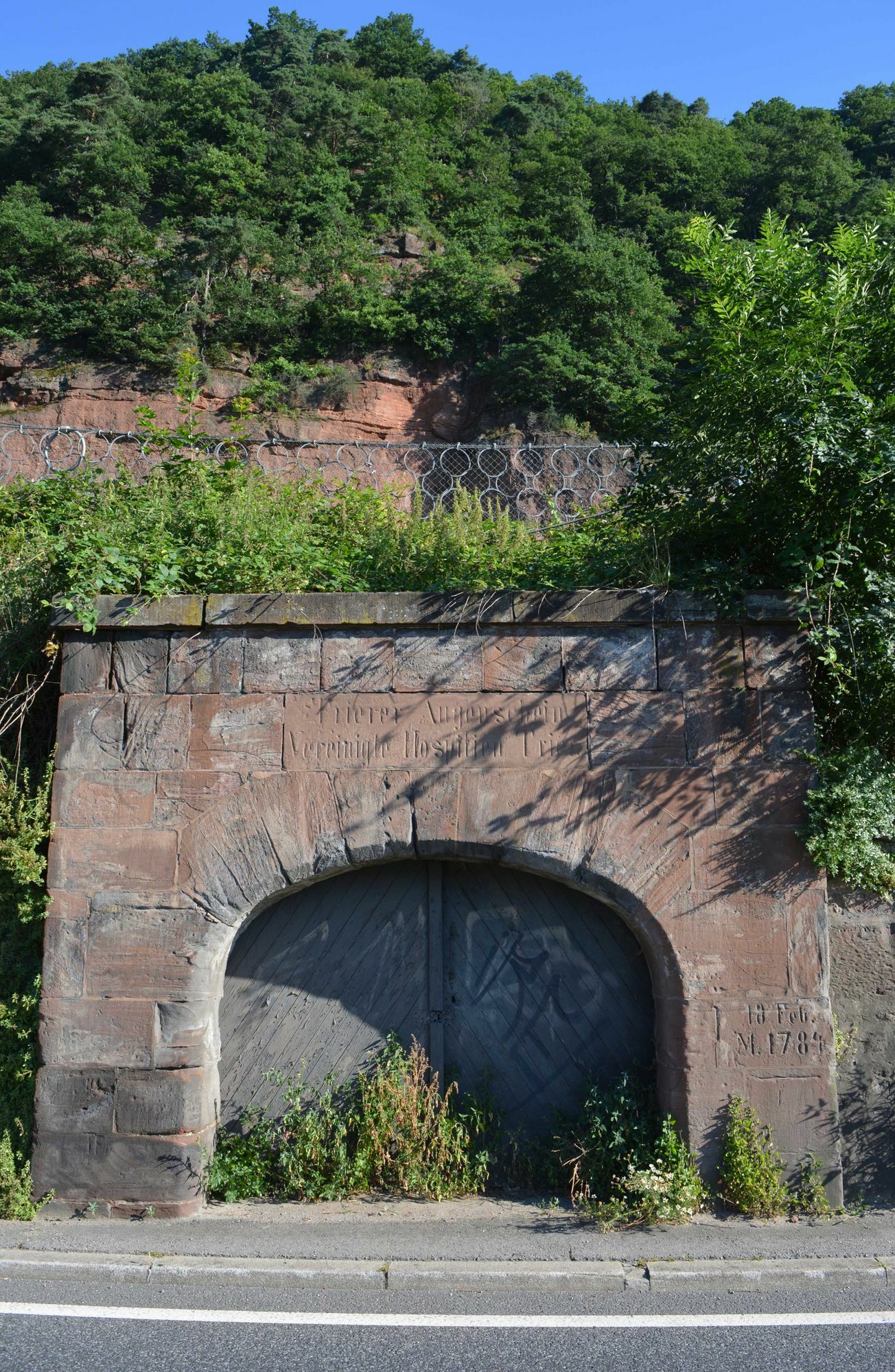 Der Augenscheiner unter den roten Felsen besitzt ein Portal mit Inschrift. Foto: Neumann