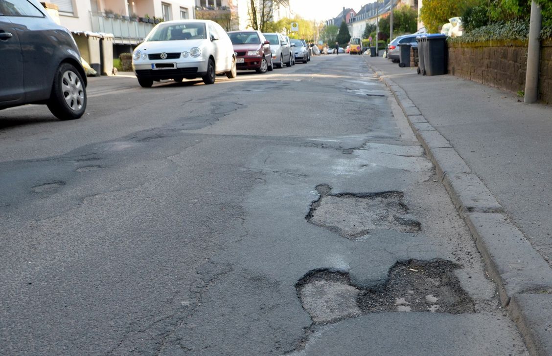 Die Kurfürstenstraße in Trier-Ost gleicht einer Kraterlandschaft, sowohl am Straßenrand ...