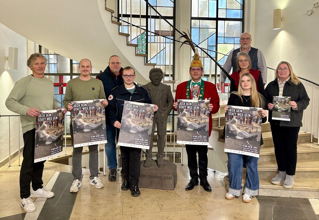 Kooperationspartnerinnen und -partner sowie Sponsoren präsentieren das Plakat zur diesjährigen Jugendschutzkampagne an Karneval