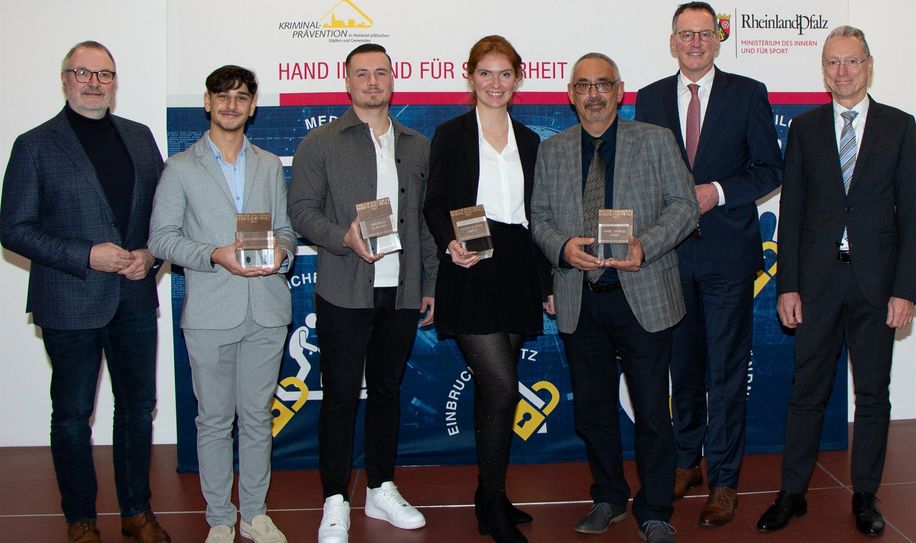 Innenminister Michael Ebling (2.v.r.) mit Generalstaatsanwalt Jürgen Brauer (r.) und dem Vorsitzenden der Stiftung Kriminalprävention, Ralf Claus (l.), sowie den Preisträgern Alpay Nedzhiyati, Jaroslav Gubenko, Laura Eberle und Marc Marcel Linke (v.l.n.r.) bei der Verleihung des Preises für Zivilcourage 2022.