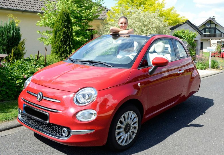 Leonie Birkmann und ihr Fiat 500, dessen Heck zu schweben scheint. Sie darf diesen Wagen mit 16 Jahren und Führerschein A 1 fahren.