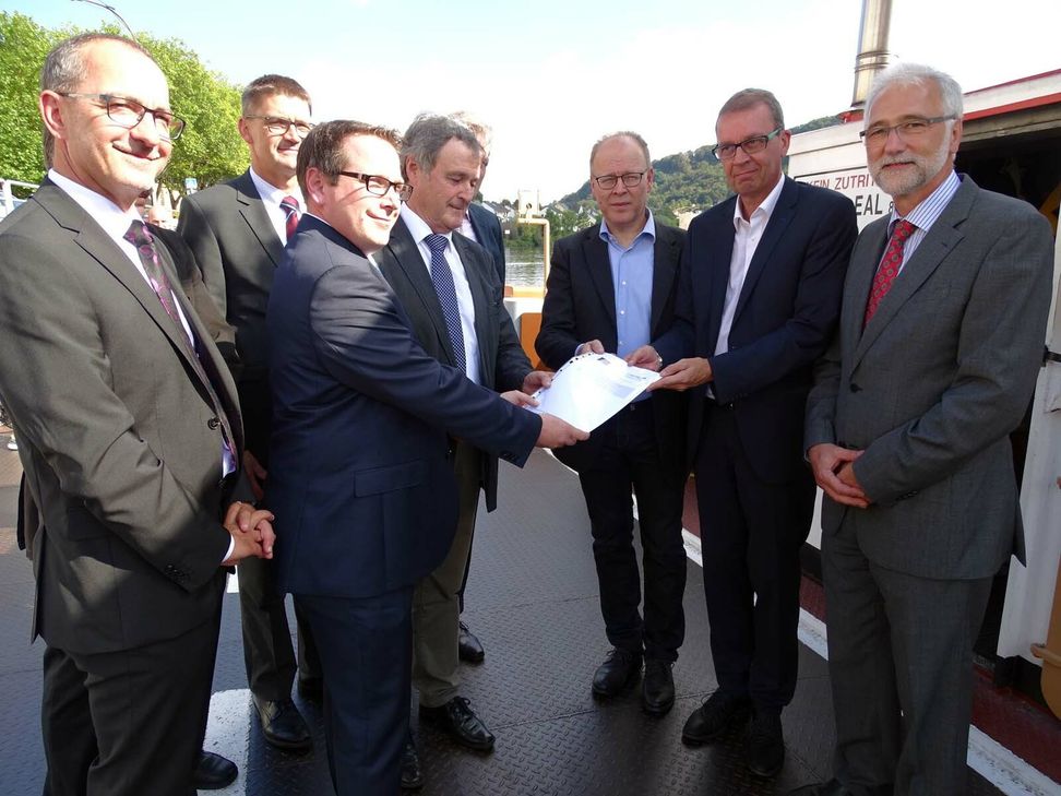 Freuen sich gemeinsam über den neuen Zuwendungsvertrag in den Händen: Thomas Linnertz (ADD, 3. v. l.), Aly Leonardy (stellvertretender Bürgermeister von Mertert/Wasserbillig, 4. v. l.), Andreas Beiling (Bürgermeister von Oberbillig, 3. v. r.), Camille Gira (Staatssekretär, 2. v. r.), Joachim Weber (1. Beigeordneter der VG Konz, l.), Günther Schartz (Landrat Trier-Saarburg, 2. v. l.) und Karl-Heinz Frieden (Bürgermeister VG-Konz). Foto: Mohsmann