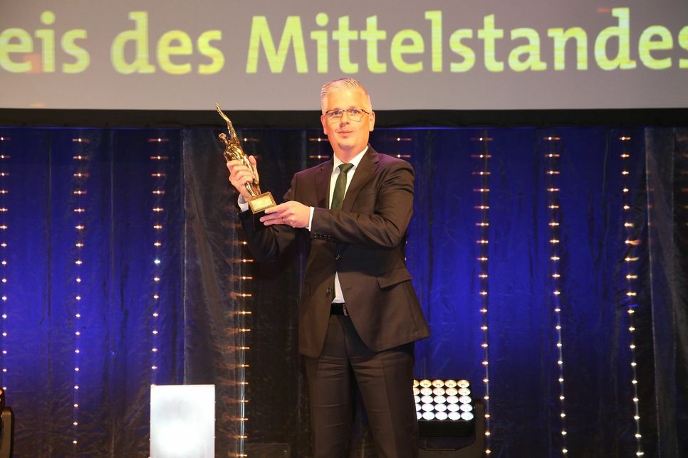 Eifeltor-Vorstandsmitglied Thomas Welter mit der Siegerstatue "Beste Bank 2020" bei der Preisverleihung in Düsseldorf.