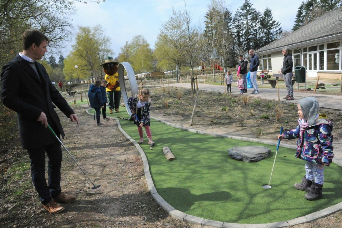 Auch Marie spielt mit auf der Adventure-Golf-Anlage von Landal Sonnenberg in Leiwen. Links im Bild: General Manager Christian Jegensdorf und im Hintergrund Bollo, der Bär. Foto: Schmieder