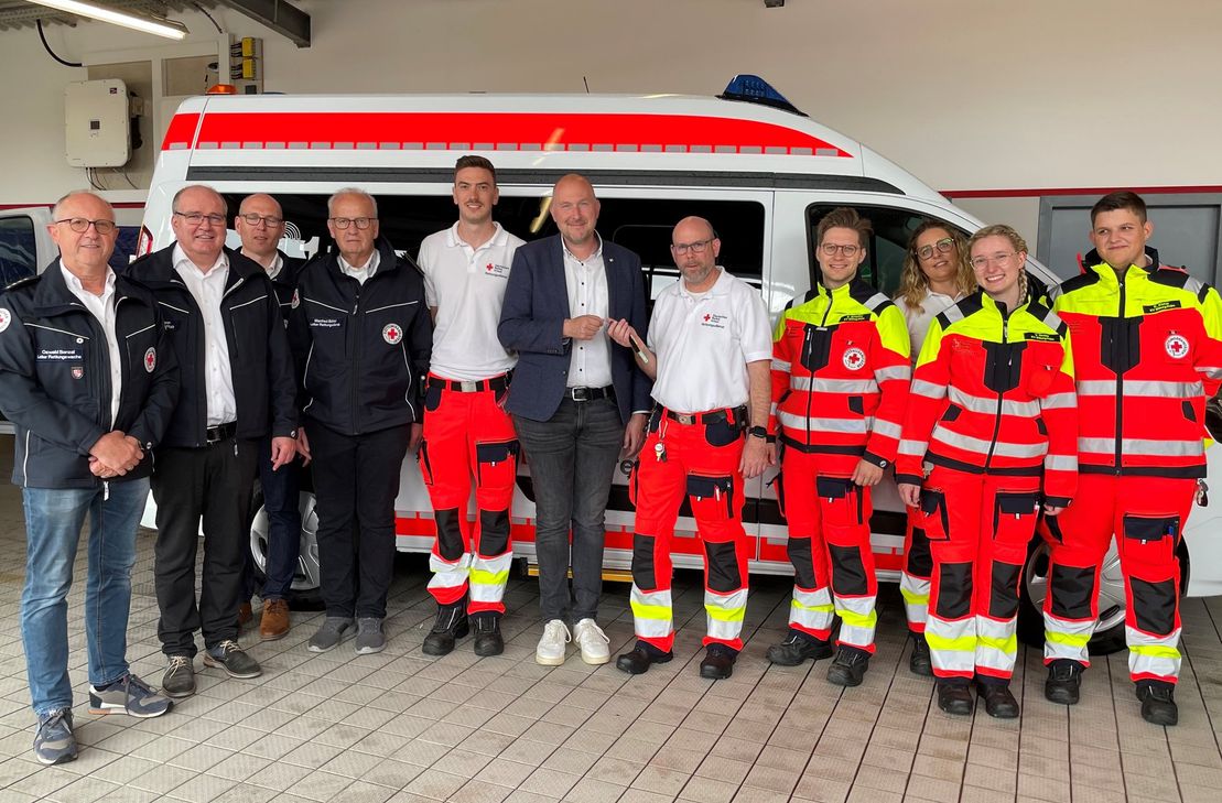 Die Rettungsdienstleitung, Kreisgeschäftsführung und das Team der Rettungswache Bitburg bei der offiziellen Fahrzeugübergabe von DRK-Präsident Andreas Kruppert an Rettungswachenleiter Michael Zimmer.