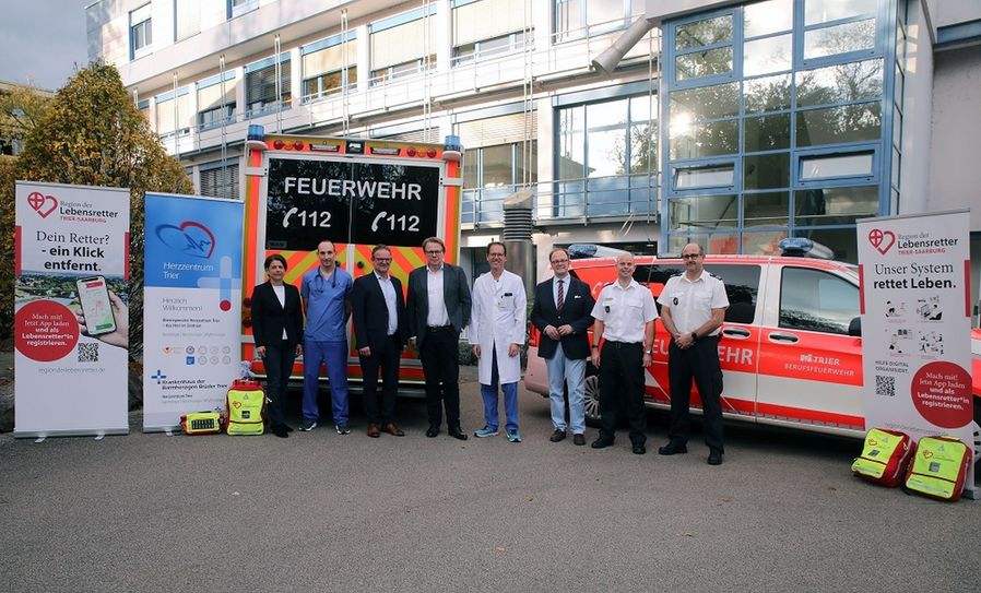 An der Einführung des Systems „Region der Lebensretter“ waren viele Stellen beteiligt: Von links nach rechts: Die Geschäftsführerin des Vereins „Region der Lebensretter“, Dr. Judith Joos; Dr. Dirk Nauheimer, stellvertretender Schwerpunktleiter Intensivmedizin Brüderkrankenhaus; Stefan Metzdorf, Landrat Kreis Trier Saarburg; Markus Leineweber, Hausoberer des Brüderkrankenhauses; Chefarzt Prof. Dr. Nikos Werner, Leiter des Herzzentrums Trier; Ralf Britten, Beigeordneter Stadt Trier; Dr. Andreas Palzer, stellvertretender Feuerwehrchef Trier; Thomas Reinholz, Abteilungsleiter Rettungsdienst Feuerwehr Trier.