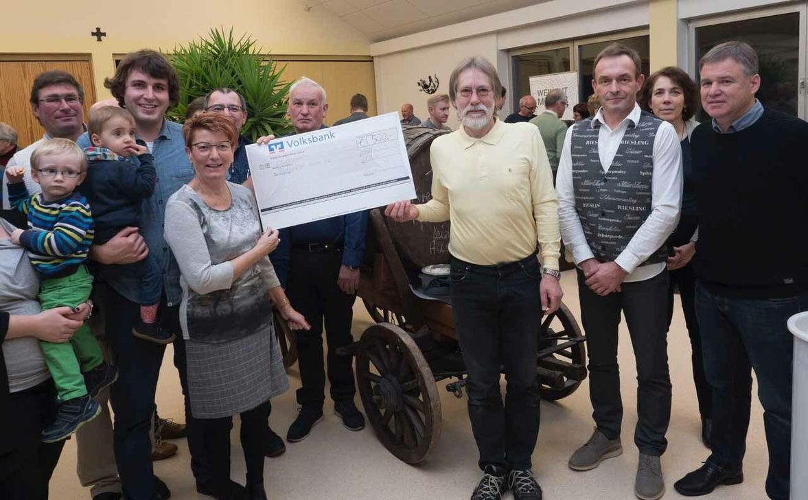 Bei der Eröffnung des Weinmarkts der Tälchen-Winzer im Bürgerhaus Krettnach konnte Pauline Zimmer, 1. Vorsitzende des Heimatvereins, einen Scheck über 500 Euro an Winzer Stefan Müller, den Vorsitzenden des Vereins "Flächenpflege Tälchen", überreichen. Foto: Willems