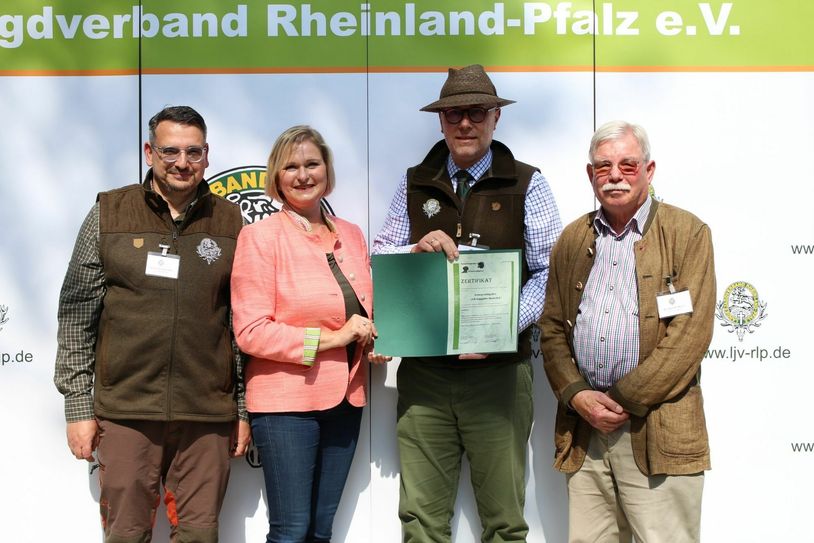 Dr. Christina Jehle übergab das Zertifikat der Kompetenzgruppe Schwarzwildgatter an LJV-Präsident Dieter Mahr (2.v.r.), LJV-Vorstandsmitglied Dr. Hans Detlef Meyer (r.) und dem 1. Gattermeister Thomas Ricklin-Thiriy (l.). (Foto: Giovannini/LJV RLP)