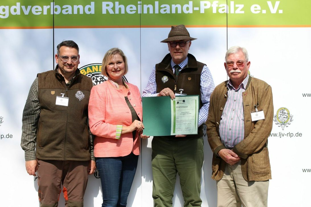 Dr. Christina Jehle übergab das Zertifikat der Kompetenzgruppe Schwarzwildgatter an LJV-Präsident Dieter Mahr (2.v.r.), LJV-Vorstandsmitglied Dr. Hans Detlef Meyer (r.) und dem 1. Gattermeister Thomas Ricklin-Thiriy (l.). (Foto: Giovannini/LJV RLP)