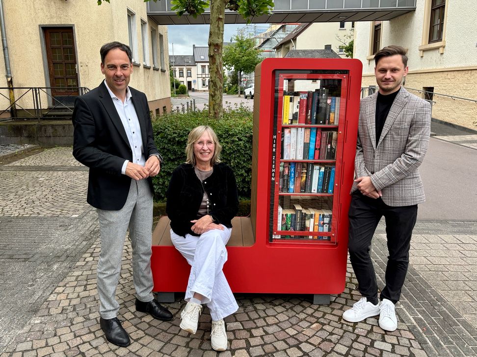 Von links: Bürgermeister Guido Wacht, Stadtbibliotheksleiterin Elisabeth Kurzmann und der Erste Beigeordnete Marcel Dawen eröffnen den neuen Bürgerschrank.