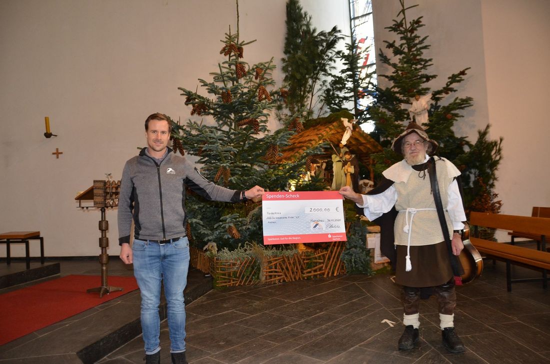 Pascal Kaulartz übergab Reiner Jakobs 2000 Euro an der kleinen Krippe in der Höfener Kirche. Die große Landschaftskrippe durfte der »singende Hirte« corona-bedingt in diesem Jahr nicht aufbauen - auch sein Gesang ist verstummt. Foto: T. Förster