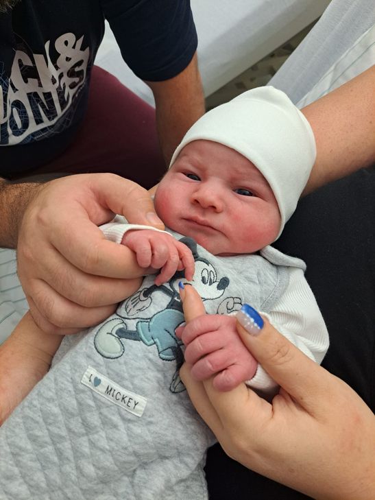 Neujahrskind Elias auf den Armen seiner glücklichen Eltern