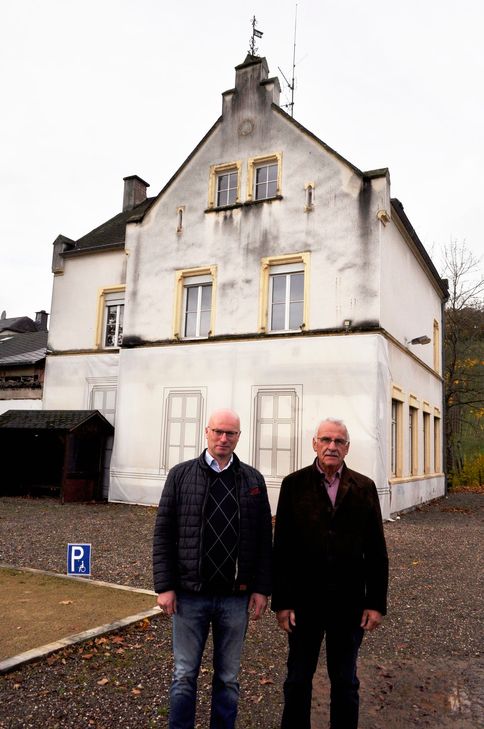 Martin Steffes und Helmut Peifer haben den Bürgerentscheid auf den Weg gebracht. Im Hintergrund: Die Alte Schule.