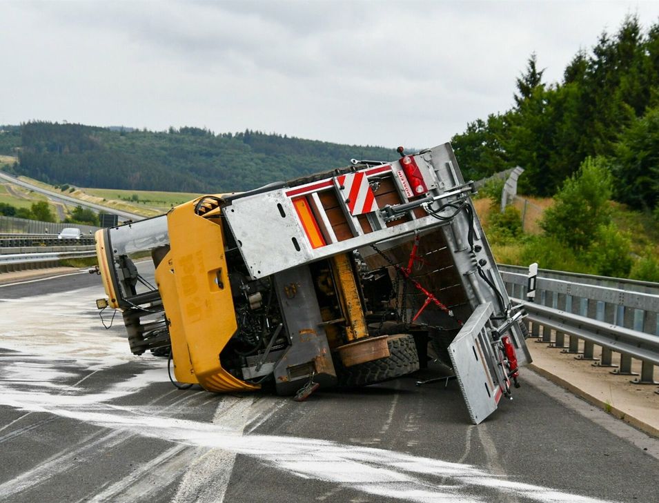 Der mit einem 13 Tonnen schweren Bagger beladene Anhänger schleuderte in die Mittelschutzplanke und kippte um.