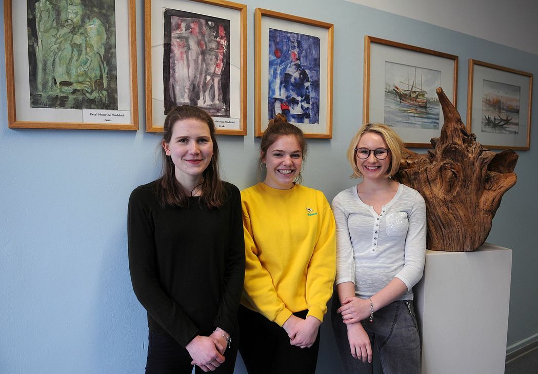 Johanna, Hannah und Franziska vor Kunstwerken von  Asylbegehrenden. Foto: Sinan Narin
