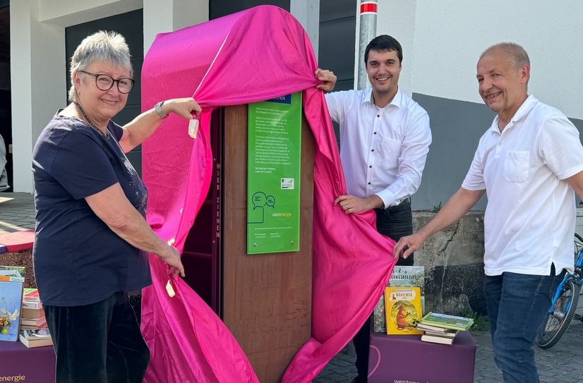 Bei strahlendem Sonnenschein enthüllten Bücherpatin Marga Stelzer, Westenergie-Regionalmanager Florian Schmidt und Ortsvorsteher Andreas Mayer unlängst den 355. Westenergie Bücherschrank in Weiler.