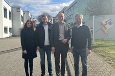 Linda Kemmer, Leiterin des Fachbereichs "Schulen und Gebäude", Johannes Schell, Technischer Objektbetreuer der Schule, Landrat Volker Boch und Marcel Nickenig, stellvertretender Schulleiter der BBS Simmern. Im Hintergrund die sanierten Bauteile E und F der BBS Simmern
