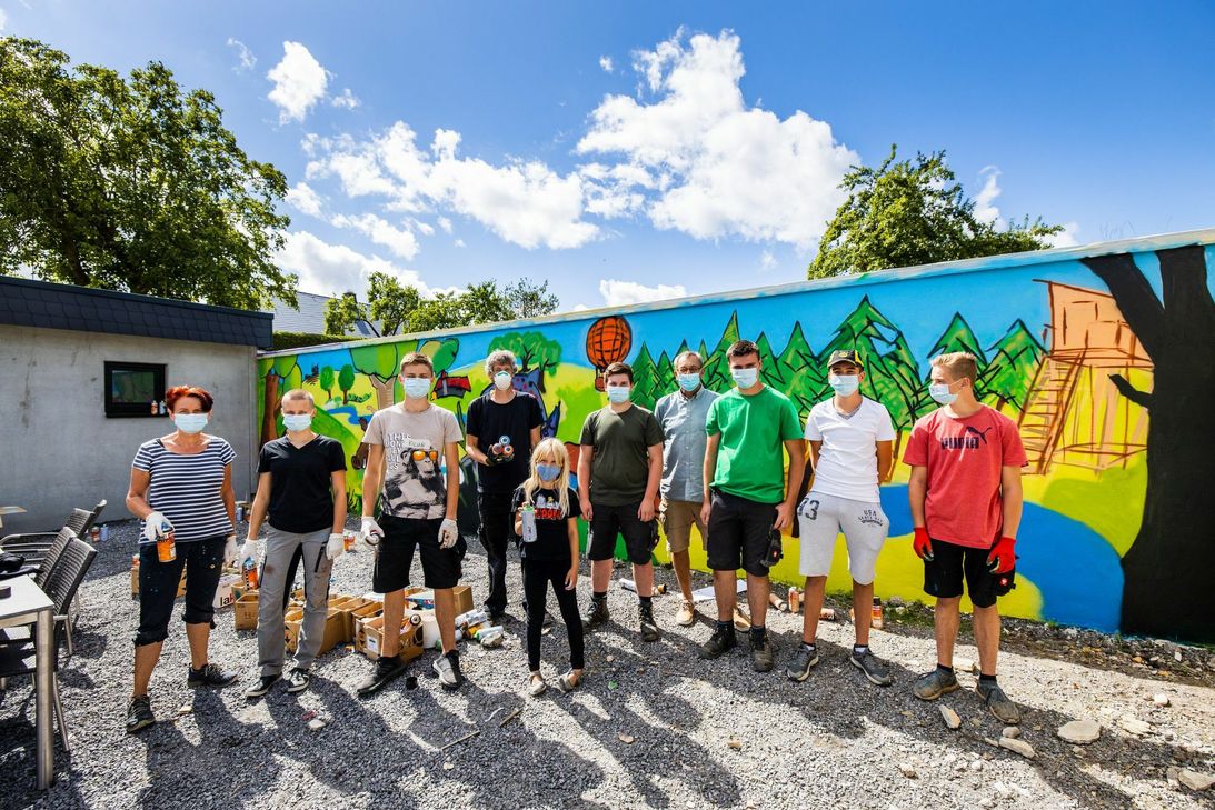 Stolze Künstler vor ihrem Kunstwerk.