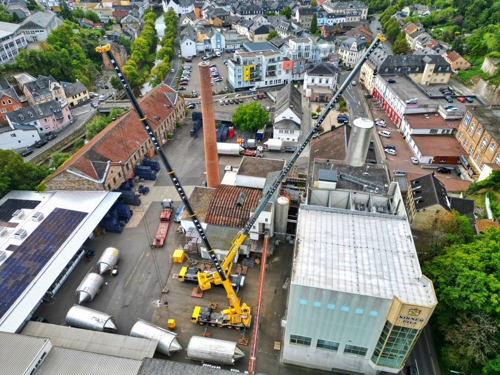 Millimeterarbeit in luftiger Höhe: Zwei Spezialkräne hieven neue Edelstahltanks in die Produktionshalle der Kirner Brauerei.