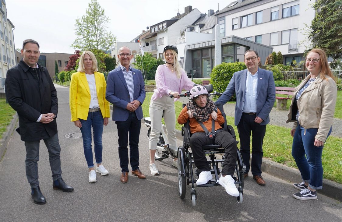 Inbetriebnahme des neuen Rollstuhlfahrrads – v.l.n.r.: Guido Wacht (Beigeordneter der VG), Stefanie Koch (Saar-Obermosel Touristik), Joachim Weber (Bürgermeister), Belma Hajdarevic und Melanie Melchisedech auf dem Fahrrad mit Kilian Zender von der Lebenshilfe und Anna-Lena Koster (Saar-Obermosel-Touristik)
