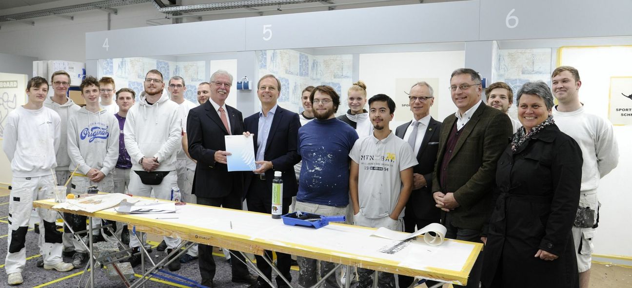 Freude bei den Auszubildenden und den Verantwortlichen der Handwerkskammer Aachen: Bildungsstaatssekretär Thomas Rachel (r.) überreichte Kammerpräsident Dieter Philipp einen Förderbescheid. Simmeraths Bürgermeister Karl-Heinz Hermanns (5.v.r.), Bildungsstätten-Geschäftsführer Wilhelm Grafen und Fachbereichsleiterin Nicole Link begrüßten die Förderung seitens der Regierung. Foto: Doris Kinkel/HWK Aachen