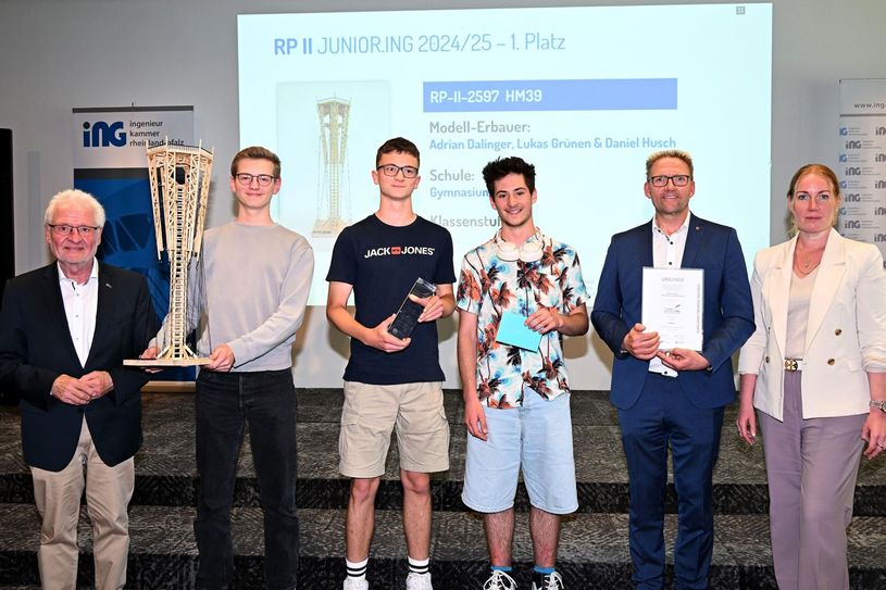 Kammerpräsident Dr.-Ing. Horst-Lenz (l.) und die Jurymitglieder Volker Tschiedel, Bildungsministerium Rheinland-Pfalz (2.v.r.) sowie Dipl.-Ing. Katharina Häuser, Kammervorstand (r.) gratulieren Adrian Dalinger, Daniel Husch und Lukas Grünen (Mitte) mit dem Modell „HM39“ zum 1. Platz in der Altersklasse II. Sie erhalten 250 Euro Preisgeld, einen Siegerpokal und eine Urkunde.