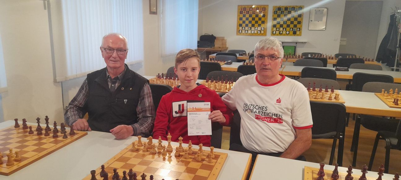 Matthias Klinkner überreicht Ben Schüller (mitte)  die Urkunde zum Deutschen Sportabzeichen im Gold im Beisein von Gerold Laux (links)