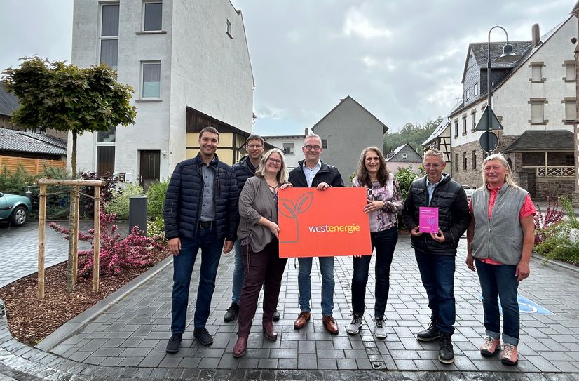 Florian Schmidt, Westenergie-Regionalmanager, Elke Roos, Ortsbürgermeisterin sowie einige der Gemeinderatsmitglieder beim symbolischen Spatenstich zur Baumpflanzaktion in Gemünden.