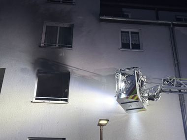 Flammen schlagen aus Fenster eines Mehrfamilienhauses