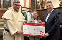 Pater Albert Seul OP und Kulturmanager Tobias Marenberg übergeben den symbolischen Spendenscheck  über 1.500 Euro an Lara Hahn für ihre gemeinnützige Initiative "origami4hope".