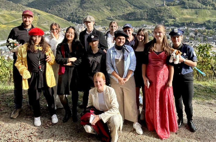 Abschluss an der Fierskapelle; (v.l.): Marcel Petri (Regie), Sheima Othmann (Moderator Heribert von Kues), Salma Othmann (Pathologin Gundula Flatulenz), Anh Thu Do Xuan (Weinprinzessin Renate Riesling), Constantin Kalles (Kommissar Kurt Kappes), Bao Ngoc Tran (Hilfspolizist), Lana Petry (Reporterin Ina Serat), Mia Stöck (Kommissarin Nicki Blaulicht), Zehra Mammadova (Landschaftsmaler Giesbart Weinberg), Bärbel Theis (Regie), Lotta Doeres (Weinprinzessin Tina Traminer), Emily Fischer (Weinprinzessin Rosa Rosé), Kaja Mieth (Polizist Klaus Herrmann mit Pfiffi.