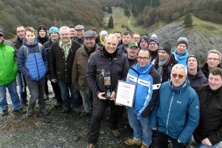 Sascha Irmiter aus Kaifenheim (mit Urkunde) inmitten seiner Feuerwehrkameraden, der durch VG-Bürgermeister Albert Jung, die Ortsbürgermeister von Laubach, Müllenbach und Leienkaul sowie den Wanderführer und Vereinsvorsitzenden Dieter Laux als 15.000. geführter Wanderer geehrt wurde.