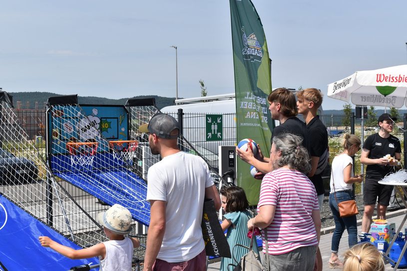 Marten Linßen mit Jannis Sonnefeld beim Körbewerfen mit den Anwesenden beim Tag der offenen Tür des neuen Premium-Partners der Gladiators Trier: "Schoenergie".