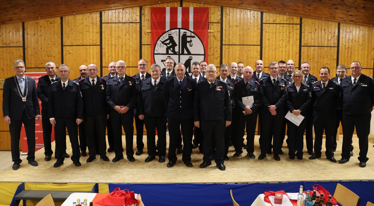 Gruppenbild mit allen Geehrten: Bei der diesjährigen Feuerwehr-Jubilarehrung in der Schützenhalle Bessenich konnte Bürgermeister Ulf Hürtgen (li.) insgesamt 32 Feuerwehrleute für 25, 35, 40, 50 und sogar 70 Jahre Treue zur Feuerwehr auszeichnen. Foto: Stadt Zülpich / Torsten Beulen