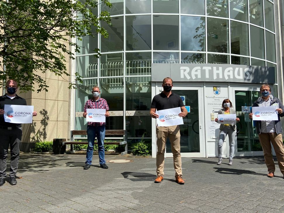 Gemeinsam mit Bürgermeister Jörg Lempertz werben Mitarbeiter der VG Mendig für die neue „Corona-Warn-App“.