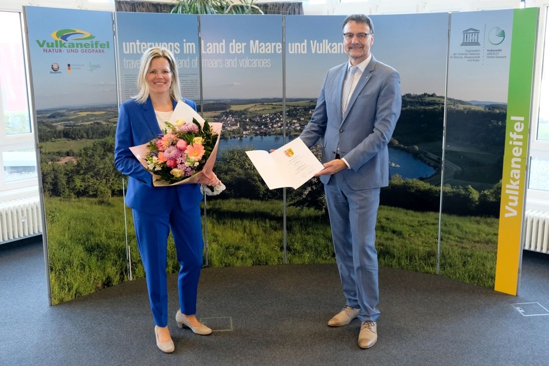 Der scheidende Landrat Heinz-Peter Thiel überreichte seiner Nachfolgerin Julia Gieseking neben einem Blumenstrauß auch die Ernennungsurkunde zur Landrätin. Foto: Kreisverwaltung Vulkaneifel / Meike Welling
