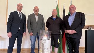 Schleidens Bürgermeister Ingo Pfennings (v.li.) nahm die Wanderkerze in Empfang, die Klaus Jansen, HaJo Meier und Udo Kraatz nach ins Rathaus gebracht haben. Auf ihr sind die Namen der Flutopfer vermerkt. 	Foto: Michael Nielen