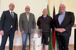 Schleidens Bürgermeister Ingo Pfennings (v.li.) nahm die Wanderkerze in Empfang, die Klaus Jansen, HaJo Meier und Udo Kraatz nach ins Rathaus gebracht haben. Auf ihr sind die Namen der Flutopfer vermerkt. 	Foto: Michael Nielen