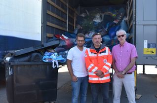 Tobias Fichtel (von links), Thomas Bollig und Thomas Lorenz vor einem LKW, der Altkleider zur Weiterverwertung transportiert.