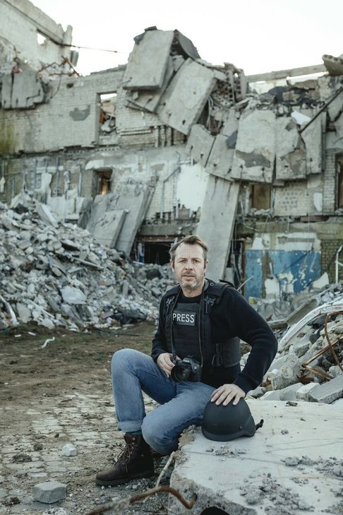 Das Foto zeigt Kriegsreporter Florian Bachmeier vor einem zerstörten Haus im umkämpften Cherson.