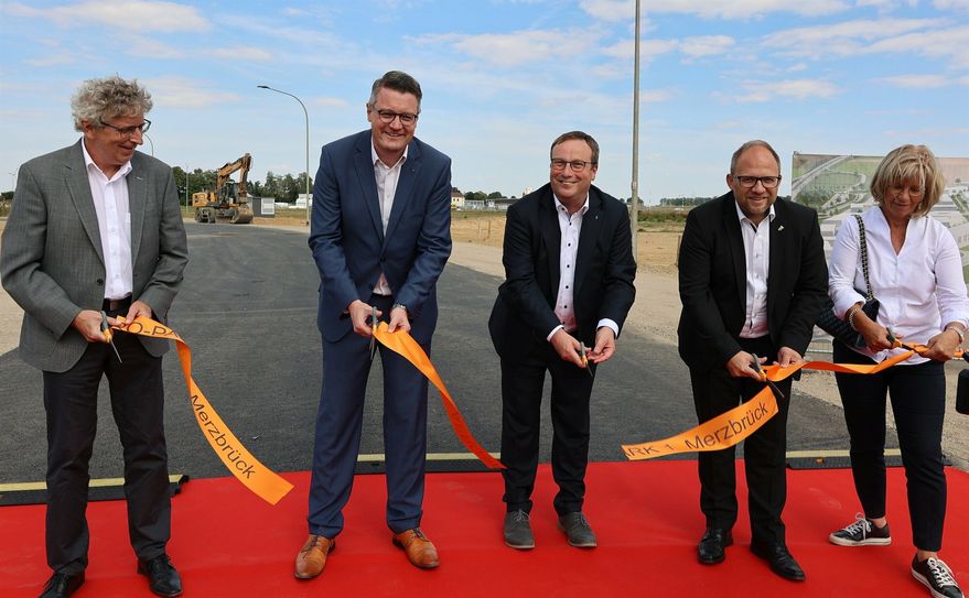 Sie stehen bei der Eröffnung des ersten Bauabschnittes des Aero Parks 1 in Merzbrück auf einem »Roten Teppich«, den sie alle gemeinsam den Unternehmen am Aachener Kreuz ausrollen: Von links: Der Geschäftsführer der Aachener Kreuz Merzbrück GmbH &amp; Co. KG, Dr. Edgar Pasderski, Städteregionsrat Dr. Tim Grüttemeier, der Minister für Umwelt, Naturschutz und Verkehr des Landes Nordrhein-Westfalen, Oliver Krischer, Würselens Bürgermeister Roger Nießen und die Geschäftsführerin der FAM, Ruth Roelen.